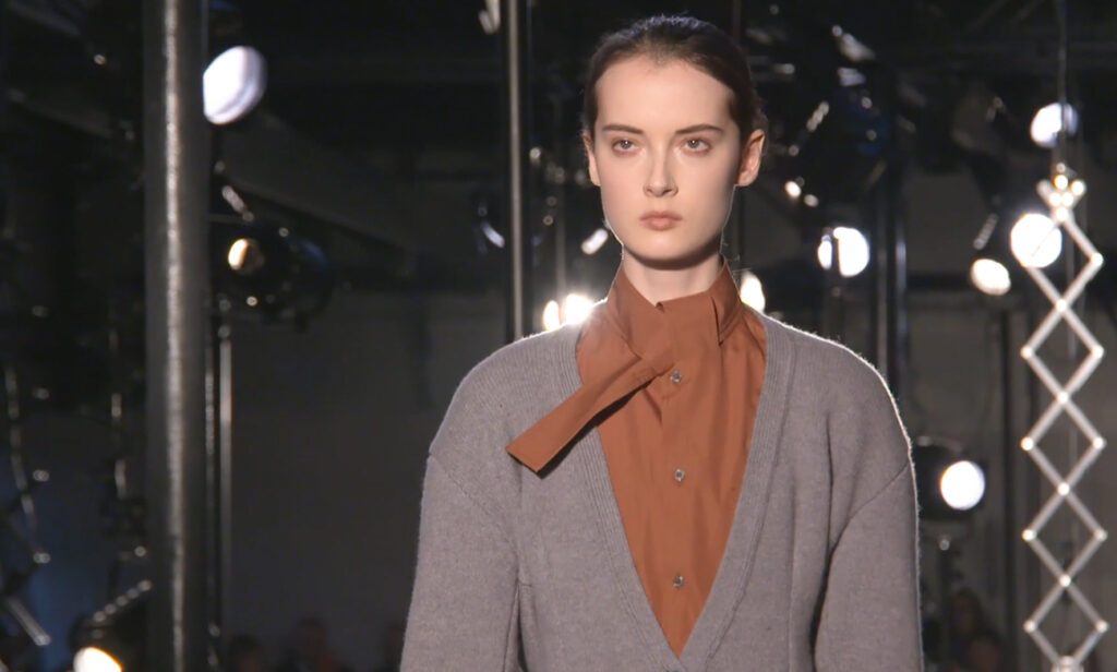 Closeup shot of an outfit with a stunning leather skirt in gray, a gray pullover and a brown shirt. Chic Winter Looks by Alessandro Dell'Acqua and N21 Fall Winter 2020