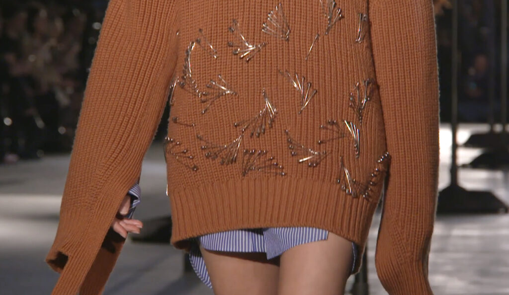 Close-up shot of a stunning brown pullover with metalic decorations. Chic Winter Looks by Alessandro Dell'Acqua and N21 Fall Winter 2020