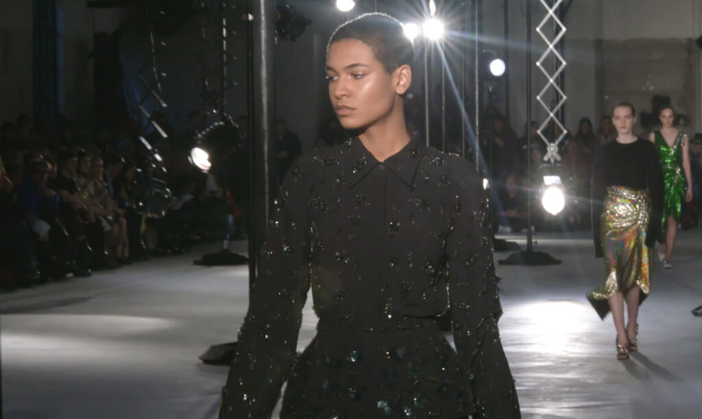 Close-up shot of a black evening wear metallic outfit with black reflective elements. Chic Winter Looks by Alessandro Dell'Acqua and N21 Fall Winter 2020